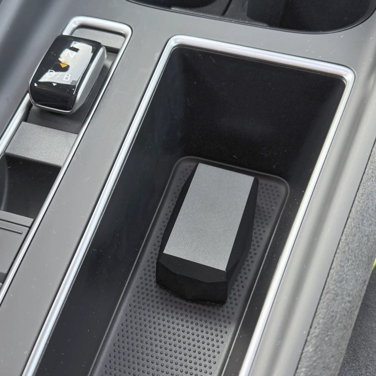 Gemstone GPS tracker inside a car center console organiser tray with a silver trim.