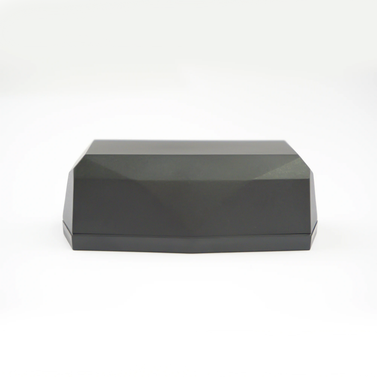Side view of Gemstone GPS tracker; a black faceted geometric shape, on a clean white studio background.